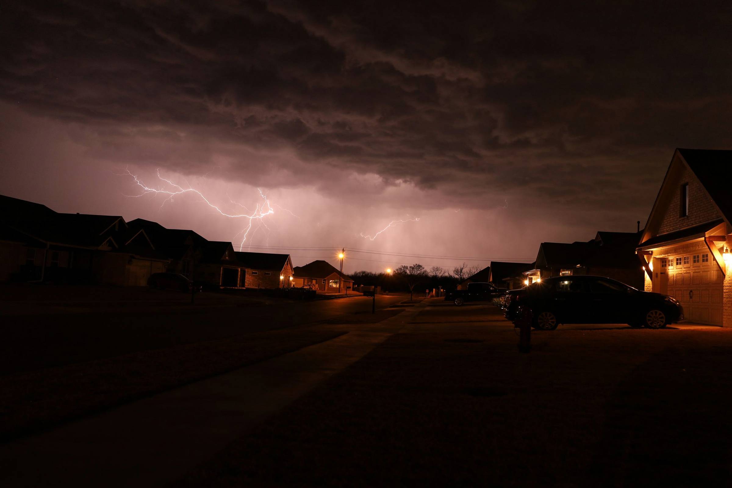 Lightning over a quiet neighborhood street at night